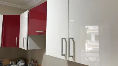 a kitchen with red and white cabinets in a kitchen at Relaxing Stay in Martil CalmView in Oulad Akkou