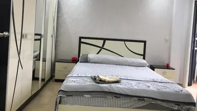 a bedroom with a bed with a black frame and a mirror at Relaxing Stay in Martil CalmView in Oulad Akkou