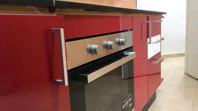 a red and black oven in a kitchen at Relaxing Stay in Martil CalmView in Oulad Akkou