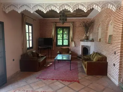 a living room with couches a table and a fireplace at Exceptional villa in Marrakech - privacy and comfort in Heddad