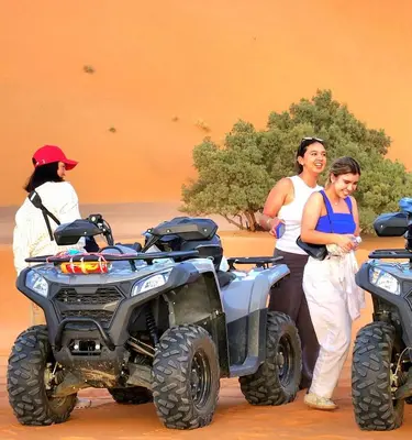 a group of people standing next to a four wheeler at Tranquil gem luxury camp in Merzouga