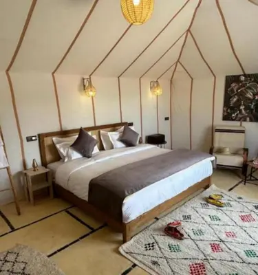 a bedroom with a large bed in a tent at Tranquil gem luxury camp in Merzouga
