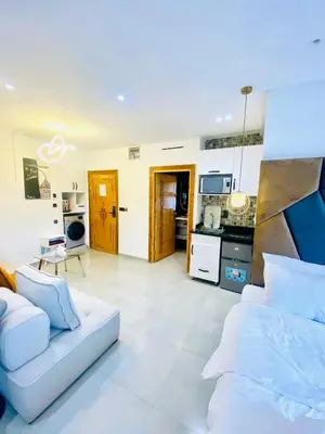 a living room with a white couch and a kitchen at nouvelle studio climatisé in Fès