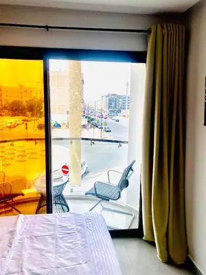 a room with a bed and a window with a chair at nouvelle studio climatisé in Fès