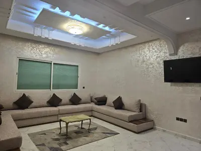 a living room with a couch and a flat screen tv at joli appartement à petit prix in Meknès