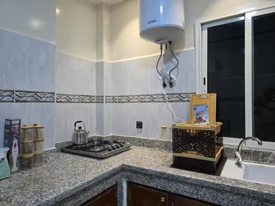 a kitchen counter with a stove and a sink at joli appartement à petit prix in Meknès