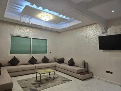 a living room with a couch and a flat screen tv at joli appartement à petit prix in Meknès
