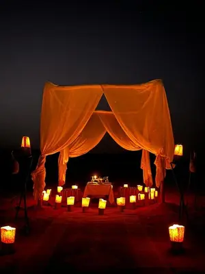 a tent with candles and lights in the dark at Merzouga Paradise Luxury Camp in Merzouga