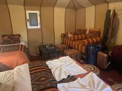 a room with beds and couches in a tent at Merzouga Paradise Luxury Camp in Merzouga