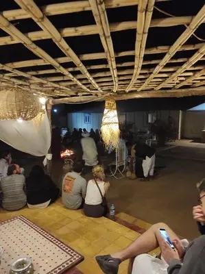 a group of people sitting on the floor under a building at Merzouga Desert Experience Camp-Erg Chebbi Sunset & Camel Ride in Merzouga