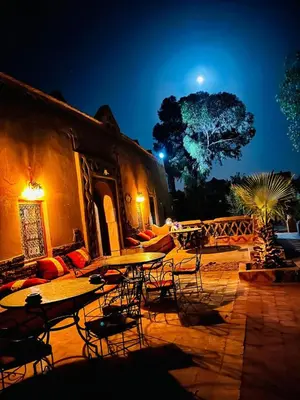 an outdoor patio with tables and chairs at night at Merzouga Desert Experience Camp-Erg Chebbi Sunset & Camel Ride in Merzouga