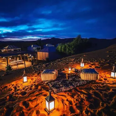 a group of tables and lights in the desert at night at Merzouga Desert Experience Camp-Erg Chebbi Sunset & Camel Ride in Merzouga