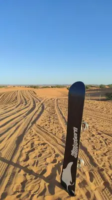 a snowboard sitting in the sand in the desert at Merzouga Desert Experience Camp-Erg Chebbi Sunset & Camel Ride in Merzouga