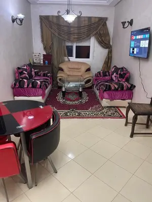 a living room with purple couches and a tv at Bel Appartement à louer à Fès in Fès