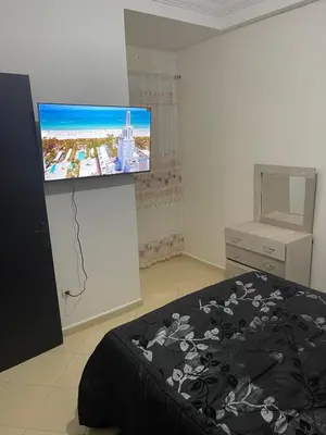 a bedroom with a bed and a flat screen tv at Bel Appartement à louer à Fès in Fès