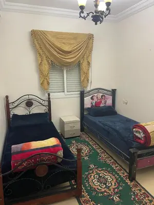 a bedroom with two beds and a window at Bel Appartement à louer à Fès in Fès