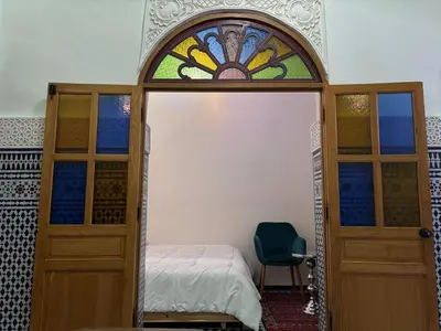 a bedroom with a bed and a stained glass window at M & S Guest House in Fès