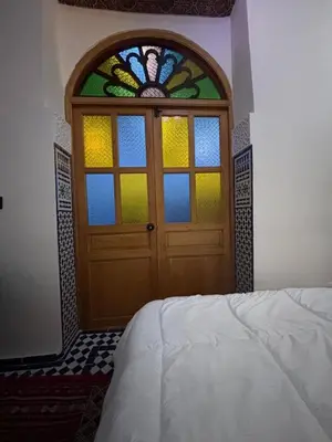 a bedroom with a door with a stained glass window at M & S Guest House in Fès