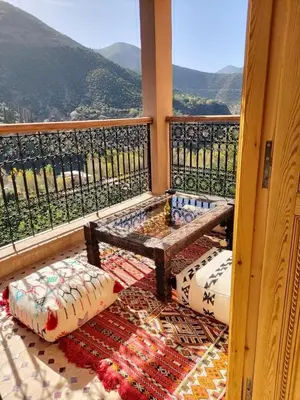 a balcony with a bench and pillows on the floor at Dar Dahlia Atlas Valley in Oulad Akkou