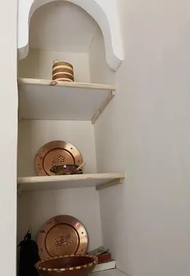 a walk in pantry with plates and bowls on shelves at Dar Dahlia Atlas Valley in Oulad Akkou