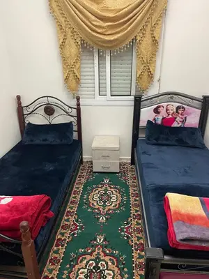 a bedroom with two beds and a rug at Bel appartement à louer à Fès in Fès