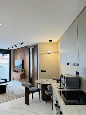 a kitchen and living room with a table and chairs at Majestic apt Casa City Center in Oulad Akkou