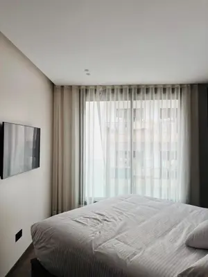 a bedroom with a bed and a large window at Majestic apt Casa City Center in Oulad Akkou
