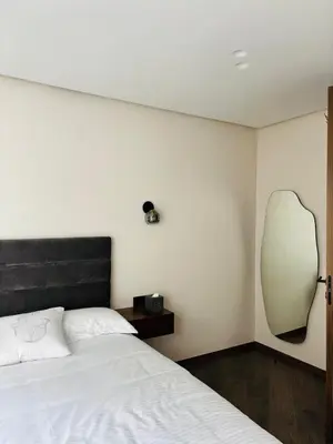 a bedroom with a bed and a mirror on the wall at Majestic apt Casa City Center in Oulad Akkou