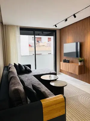 a living room with a couch and a flat screen tv at Majestic apt Casa City Center in Oulad Akkou