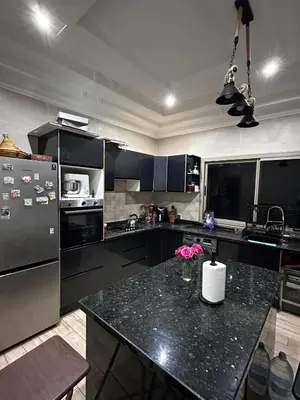 a kitchen with black cabinets and a black counter top at Villa Adam in Meknès