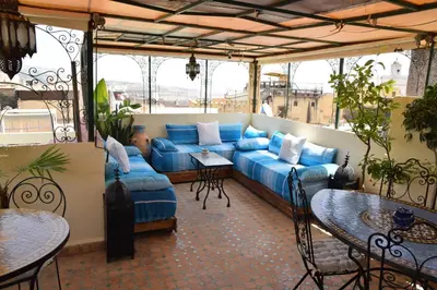 a living room with a blue couch on a balcony at Dar Omar in Fès
