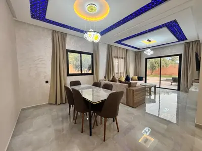 a living room with a table and a couch at Villa avec piscine Aghmat in Aghmat