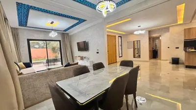 a living room with a table and a couch at Villa avec piscine Aghmat in Aghmat
