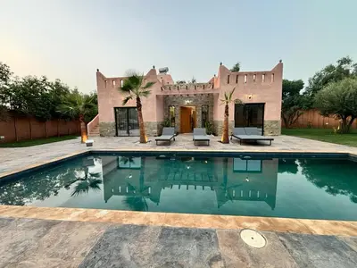 a villa with a swimming pool in front of a house at Villa avec piscine Aghmat in Aghmat