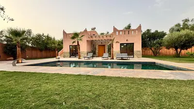 a villa with a swimming pool in front of a house at Villa avec piscine Aghmat in Aghmat