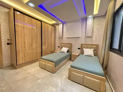 two beds in a room with purple lights at Villa avec piscine Aghmat in Aghmat