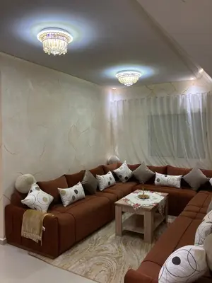 a living room with a brown couch and a table at Cozy Family-Friendly Stay with Unique Decor in Ifrane in Ifrane