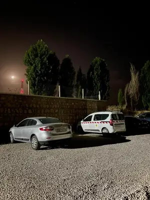 two cars parked in a parking lot at night at Cozy Family-Friendly Stay with Unique Decor in Ifrane in Ifrane