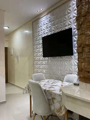 a dining room with a table and a tv on a wall at Cozy Family-Friendly Stay with Unique Decor in Ifrane in Ifrane