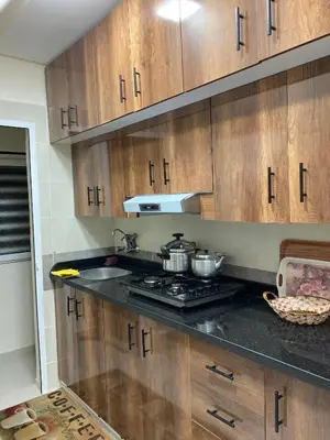 a kitchen with wooden cabinets and a stove top oven at Cozy Family-Friendly Stay with Unique Decor in Ifrane in Ifrane