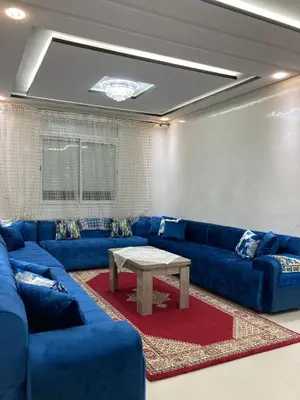 a living room with blue couches and a table at Modern Apartment in Ifrane in Ifrane