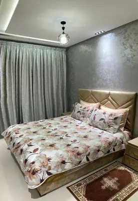 a bedroom with a bed with a floral comforter at Modern Apartment in Ifrane in Ifrane