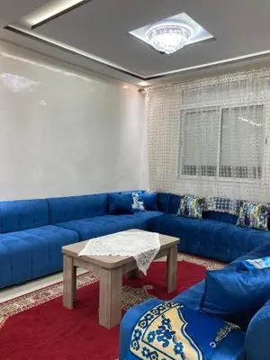 a living room with a blue couch and a table at Modern Apartment in Ifrane in Ifrane