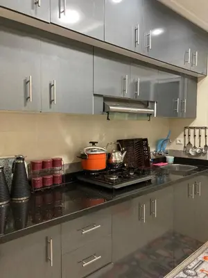 a kitchen with gray cabinets and a stove top oven at Modern Apartment in Ifrane in Ifrane