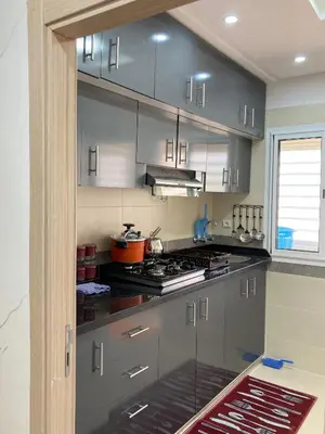 a kitchen with gray cabinets and a stove top oven at Modern Apartment in Ifrane in Ifrane