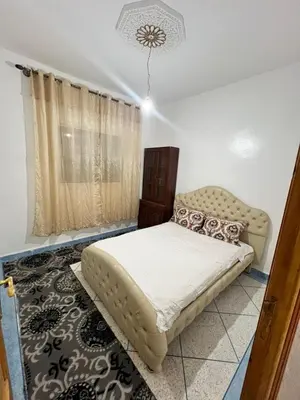 a bedroom with a bed and a chair in it at Au centre de la ville pour les familles seulement in Khenifra