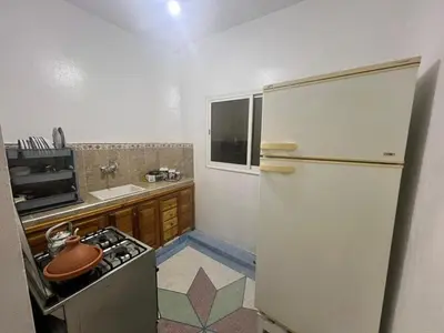 a small kitchen with a refrigerator and a sink at Au centre de la ville pour les familles seulement in Khenifra