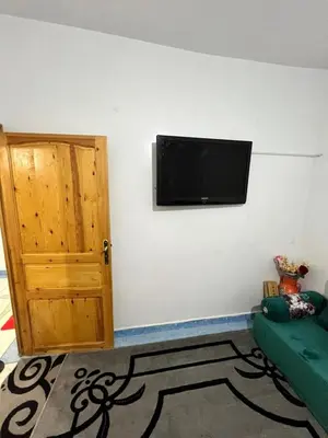 a room with a flat screen tv on a wall at Au centre de la ville pour les familles seulement in Khenifra
