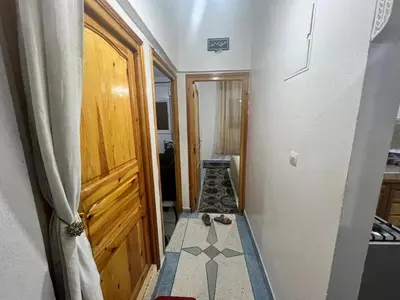 a hallway with a wooden door and a tile floor at Au centre de la ville pour les familles seulement in Khenifra