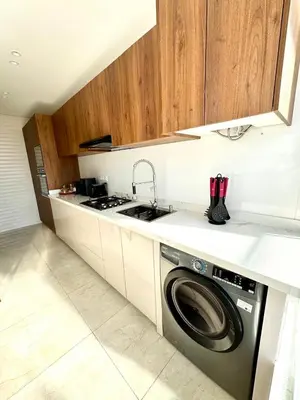 a kitchen with a washing machine and a stove at La casa famille in Oulad Akkou